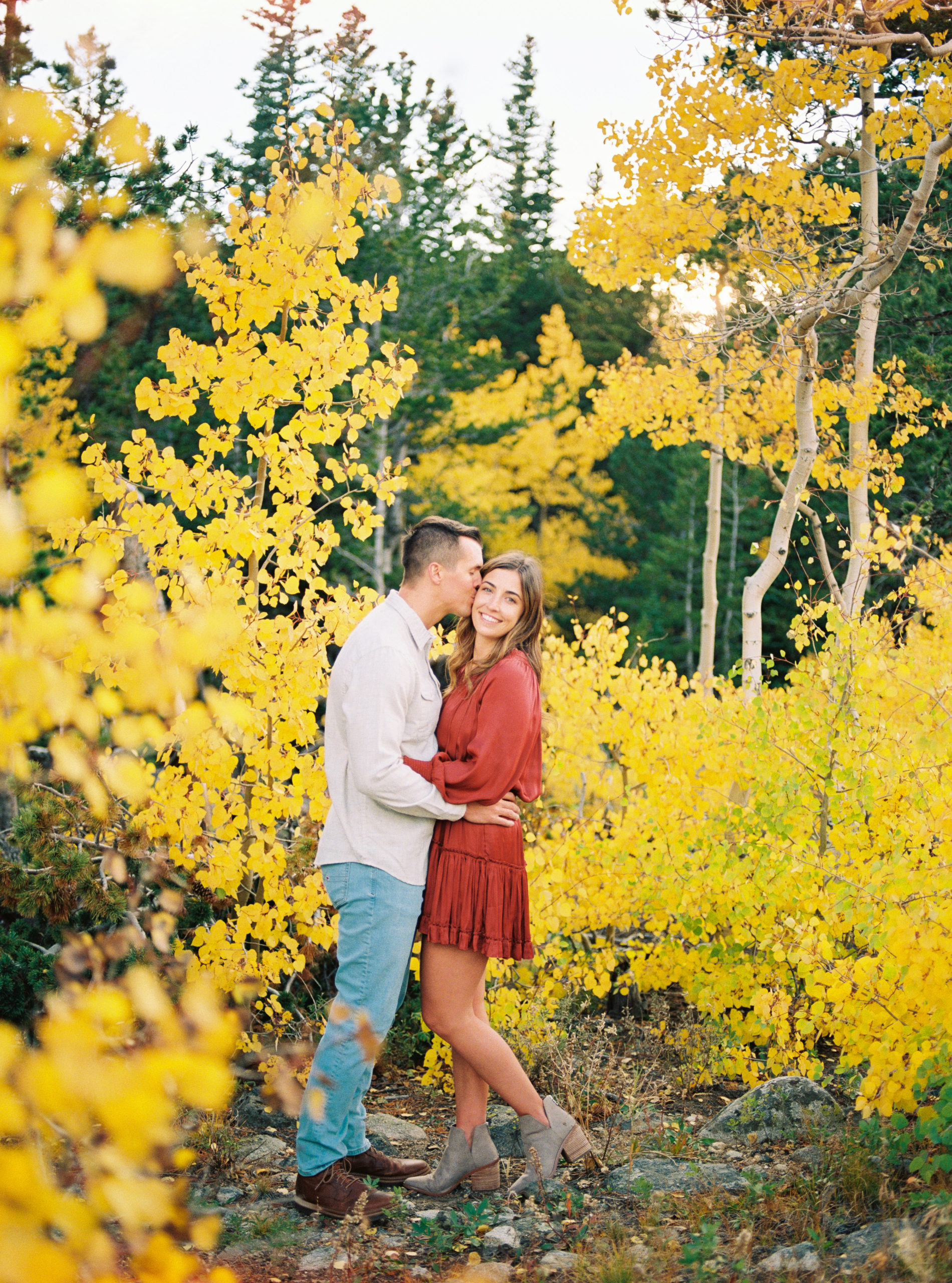 Engagement portrait of a couple in Fall colors at a Colorado mountain lake