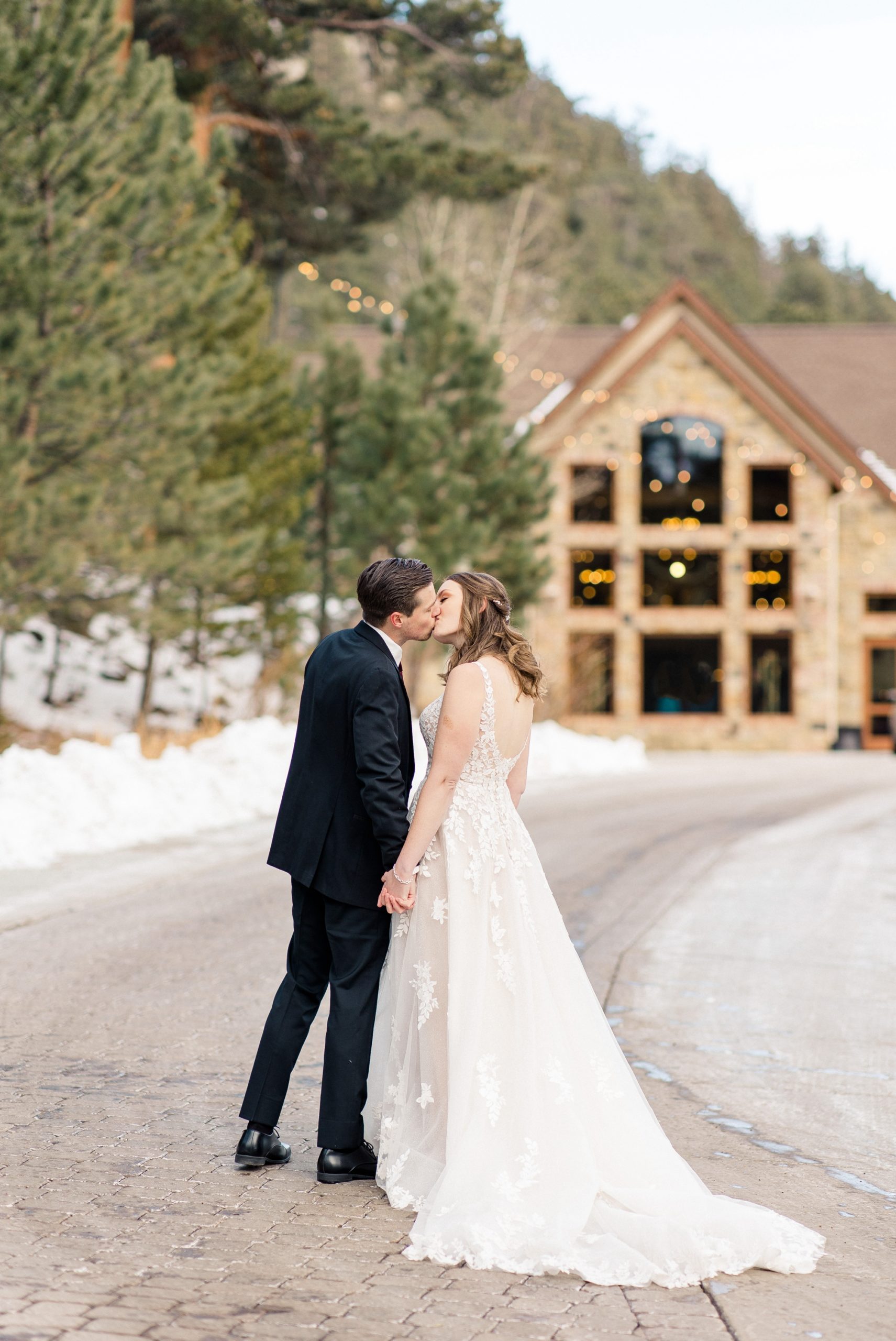 Couple kissing in front of Della Terra Mountain Chateau wedding venue in Estes Park