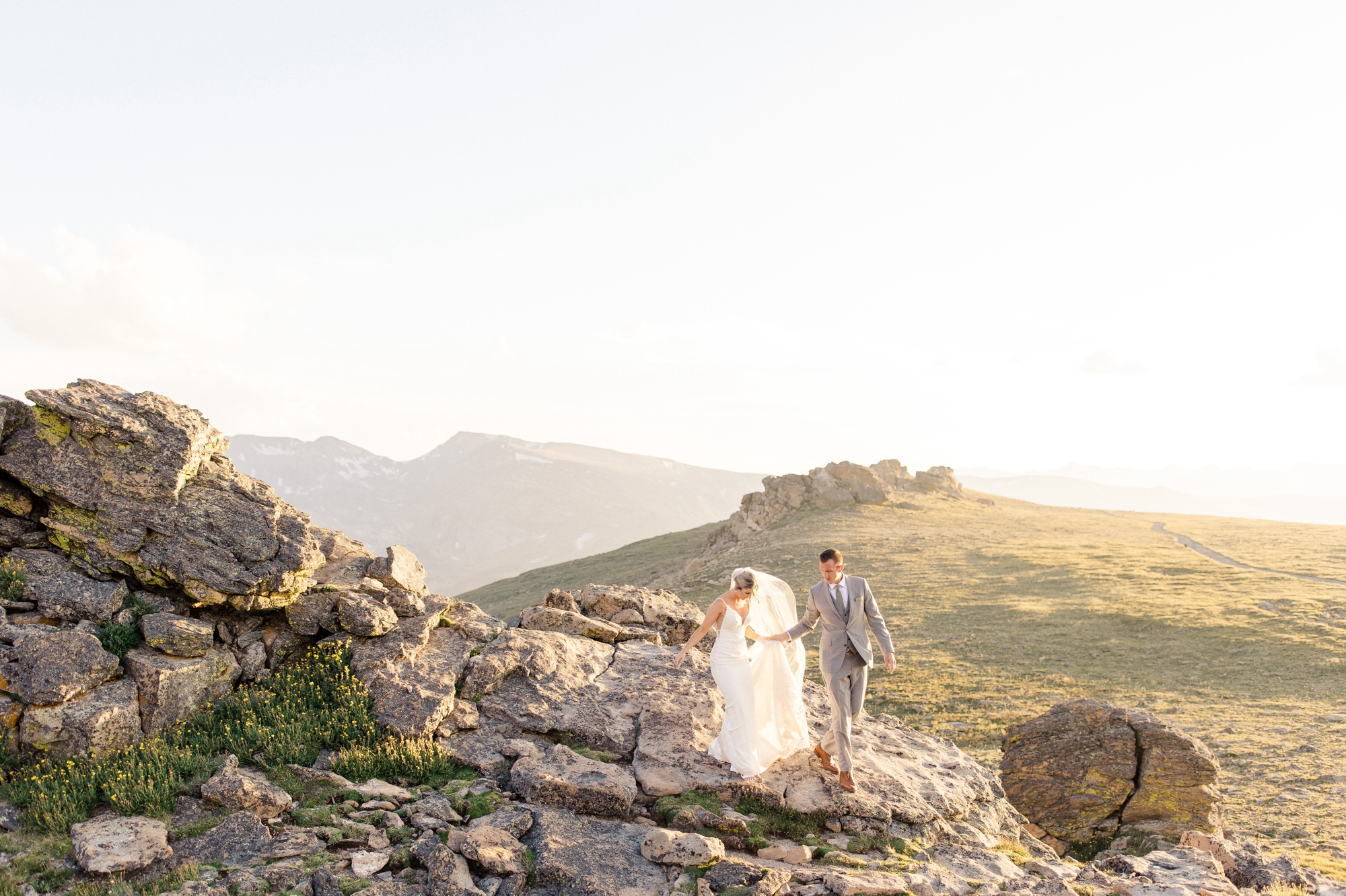 Couple walking hand in hand in Rocky Mountain National Park in Estes Park, photographed at golden hour