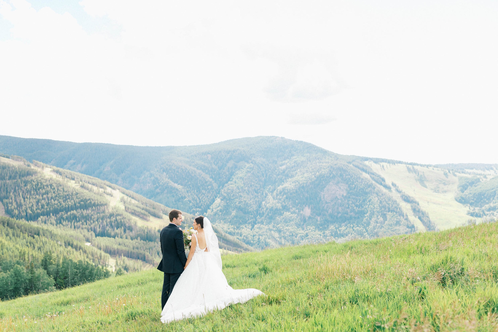 Wedding couple facing away in vast mountain portrait in Beaver Creek wedding