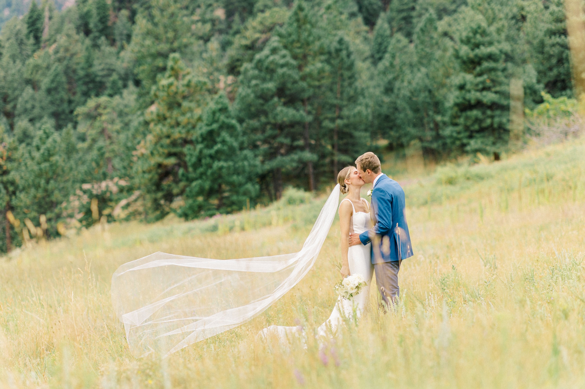 Bride and groom, kissing in Mountain field in Boulder, Colorado