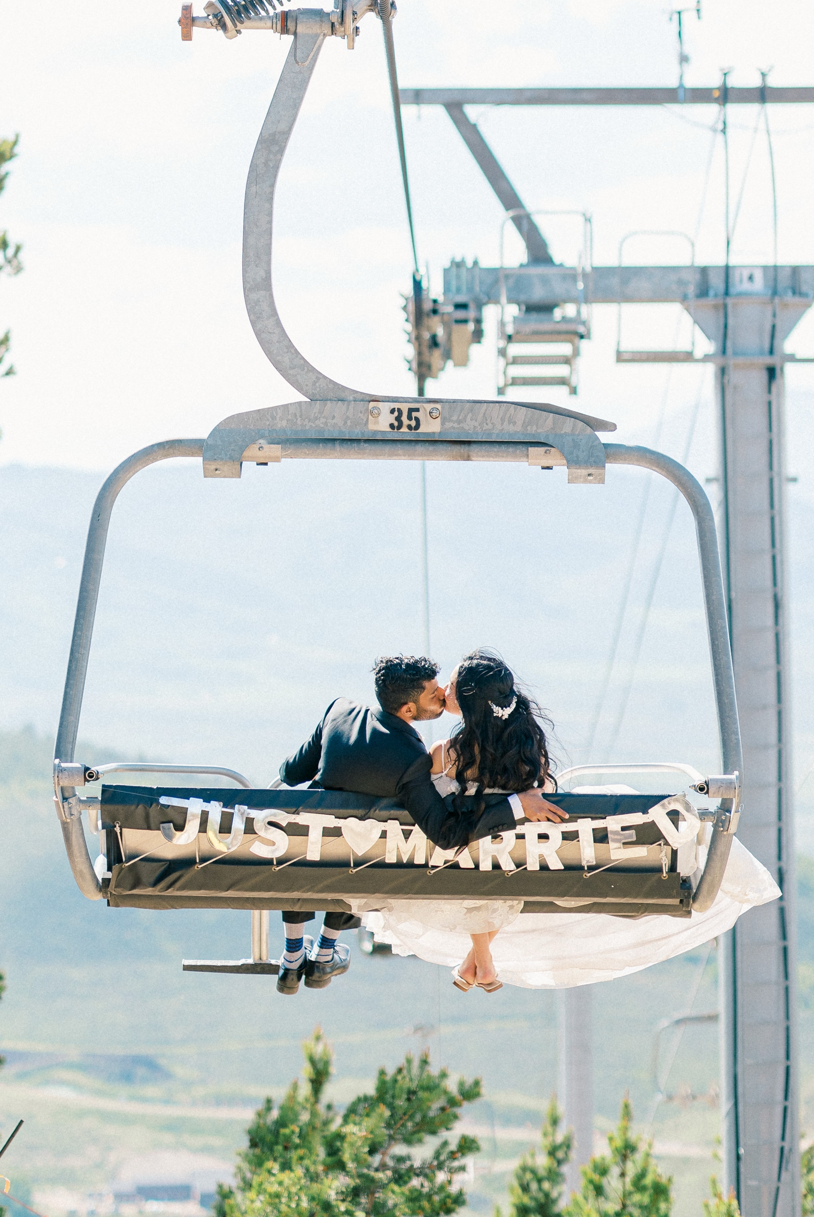 Bride and Groom riding ski lift at Granby Ranch Mountain wedding